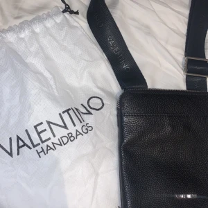 Valentino axelremsväska  - Nästan aldrig använd! Helt nytt skick och en dustbag till. Äkta skinn. Säljaren står för frakt! Höjd: 22cm Längd: 20cm Vidd: 2cm