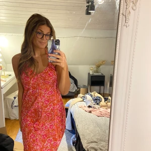 Röd och fin sommarklänning - En fin blommig klänning som man knyter runt halsen som inte är använd på flera år❤️ det är storlek 44 men jag är 36 så den är liten i storleken.