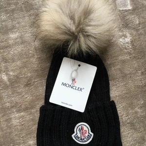 Moncler mössa - Säljer min helt nya moncler mössa. Den är i nyskick dvs aldrig använd. Kvitto finns tyvär ej då jag fått mössan i present. Köparen står för frakten. Mössan är i cashmere ovh pälsbollen är i äkta tvättbjörnspäls. Pris kan diskuteras 