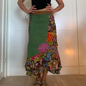 Färgglad omlottkjol  - Färgglad omlottkjol med små pompoms vid midjan. Väldigt vacker o flowig🌻  Knyts med band så väldigt justerbar. Allt från XS till L
