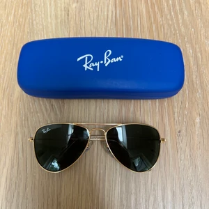 RayBan solglasögon  - Junior solglasögon från RayBan. Mörk lins, guldram med tillkommande orginalförpackning. Knappt använda, som nyskick. Kvitto finns