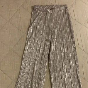 Silvriga Byxor -  Ett par silvriga byxor som aldrig har kommit till användning endast testade. Storlek XS. Betala gärna med swish och möt helst upp i Linköping. ENDAST SERIÖSA KÖPARE!!!