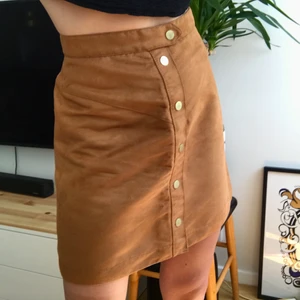 Kjol mocka imitation  - Aldrig använd kjol i mocka (imitation). Toppen skick! Översta knappen går att knäppa upp + dragkedja baktill. Strl 36. Köparen står för frakt, kan mötas i Malmö!