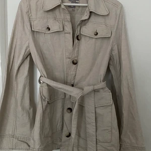 Beige jacka  - Snygg jacka med ett bälte för midjan, köpt på Elin Maria i Eskilstuna, använd fåtal gånger och säljer då det inte är min stil längre ❤️❤️ kan mötas upp i Eskilstuna annars betalas frakt av köparen ☺️🌟
