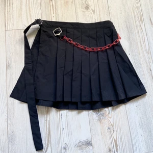 Kjol med kedja ⛓ - Cool kjol med röd kedja och spänne så att man kan justera midjan som man vill 🖤 Köpt här på Plick men oanvänd så kjolen är i nyskick! Skriv privat om du har frågor 🤍