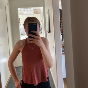 Linne - Ett rostrött linne med öppning i ryggen. Ribbat och stretchigt material. Köpt från zarlando och använd endast två gånger. Superfint skick! Frakten ingår ej i priset💚