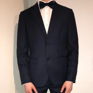 Navyblå Bläck herrkostym - Dresskostym i Tailored fit använd på en skolavslutning, köpt för 2500kr. James Blazer ljust marinblå med tillhörande James Trousers. Modell på bilden är normalbyggd 180 cm lång. Köpare står för frakt. Hör av dig vid funderingar!