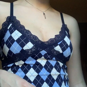 Rutig ribbad topp :) - Jag köpte denhär för kanske 5 ish månader sen, bra skick. Toppen är lite croppad och ganska tunn, skulle dock inte säga att den är genomskinlig. Den har reglerbara band som också är lite stretchiga. Den har en liten (antagligen köttfärssås) fläck, men den är knappast synlig :)