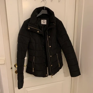 Vinterjacka / dunjacka - Knappt använd dunjacka / vinterjacka! Svart med guliga spännen och något figursydd! Knappt använd så den är som ny🤩🥰