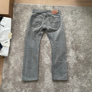 Levis 501 - Säljer ett par ljusgråa vintage Levis 501:or. Byxorna är i ”vintage” skick men det finns inga fläckar, hål eller likande. Startar budgivning på 400kr. Passar en normalstor kille på 182-185cm