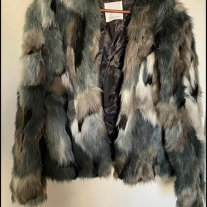 Fuskpäls från Mango strl S - Blå vit grå fuskpäls feån Mango, strl S. 2 fickor framtill. Oanvänd i nyskick. 