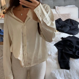 Silkesskjorta - Champagnefärgad silkesskjorta. I storlek S men sitter snyggt på en XS också. Endast använd på bilderna därav fint skick. Använd som ”kofta” över en korsettopp förra nyår (andra bilden).