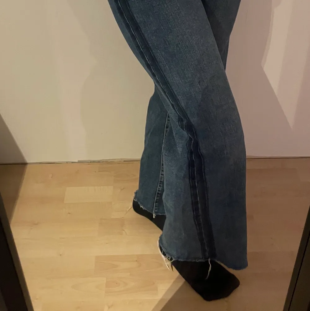 Mörkblåa vida jeans med detalj på sidan av båda benen (se andra bilden) från Lindex i storlek 36. Passar perfekt på mig som är ca 163 cm. Nypris 499kr. Priset kan diskuteras. Hör gärna av dig vid frågor!💗. Jeans & Byxor.