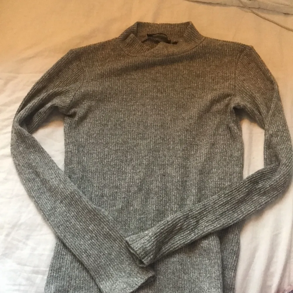 En gråaktig tröja med lite polo. Den är använd ett fåtal par gånger och sitter ganska tajt. Den är i storlek xs och har ett slags ribbat tyg. Denna säljs för 50+ 30 i frakt. Toppar.