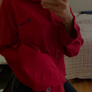 Champions Hoodie - En röd hoodie från Champions! Den är av tunt material så man kan även ha något under den. Köpt på Weekday för någon sommar sen men har ej kommit till mycket användning. Det finns ett litet hål vid tröjärmen. Kan mötas upp annars står köparen för frakt! 