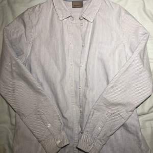 En jättefin vit och blå-randig skjorta som kommer ifrån märket VERO MODA, men är köpt på second hand! Skicket är toppen då den knappt är använd. Skriv privat för bilder på passform, mått mm❤️
