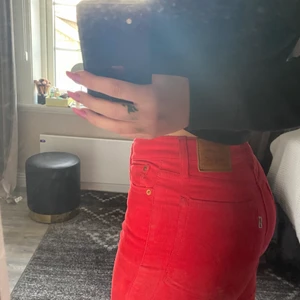Levis jeans strl 26 - Coola Levis jeans med medelhög midja och raka ben, manshester byxor i klarröd färg. 