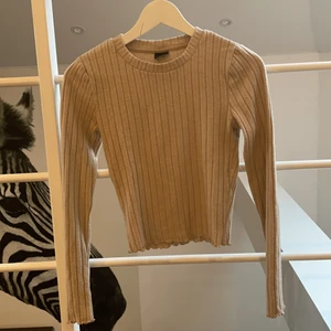 Gina tricot långärmad tröja - Långärmad tröja från Gina tricot i bra skick. Mjukt material och beige färg. Är ganska kort croppad med fina detaljer i ärmar och längst ned, och passar både XS och S även om storleken är XS.