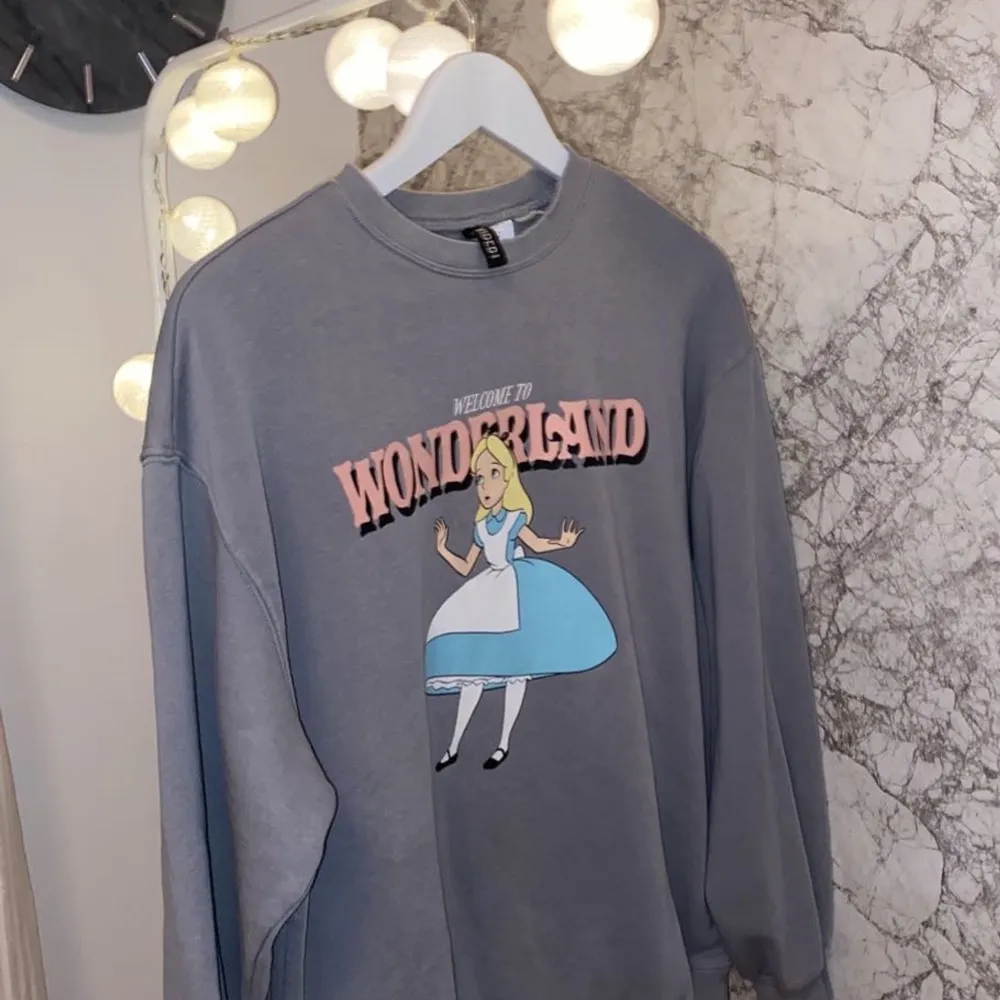 En sweatshirt med Alicie in wonderland ifrån Hm. Storlek xs men passar också s. Använd ett fåtal gånger och priset är ink frakt. . Tröjor & Koftor.