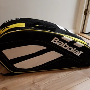 Babblat tennisväska - Den har använts i ett år av en 16-årig tjej. Den har 3 fack där man kan ha sina tennisracket i 2 av dem och sedan nödvändiga kläder eller behörigheter i den tredje. Till sist har den även ett litet fack vid sidan om där man kan ha nycklar och sådant.                                        Mått: 74 cm lång och 29 cm bred