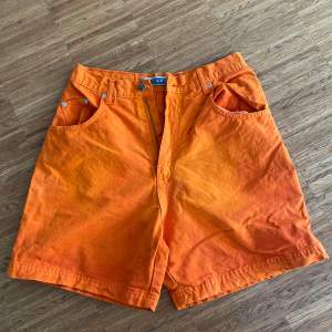 Jeansshorts i orange, rostig färg, storlek L.