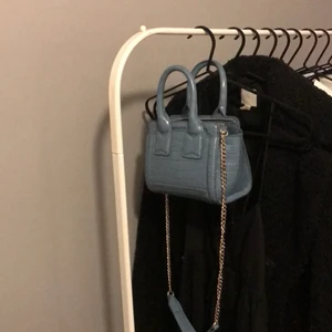blå ZARA väska - intressekoll på min oanvända väska från Zara. väskan är köpt i butik i Göteborg i somras, men aldrig använd. Etiketten är dock borttagen. Väskan är slutsåld online och är i en blåaktig färg med guldiga detaljer 🤍 bilderna på annonsen är endast mina egna. 