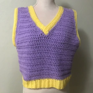 Virkad två sidig väst - Gul och lila virkad väst som går att bära på båda hållen. Samma design på båda sidorna vilket gör den helt vändbar. Lite oversize, men passar upp till L men då sitter den nog tajt