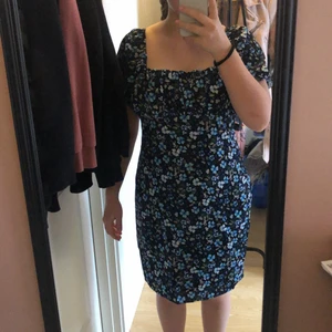 Blommig klänning strl 38 NA-KD - Klänning i strl 38 från NAKD med pösiga korta ärmar och dragkedja bak. 100% polyester. Aldrig använd. Perfekt till sommaren! Orginalpris 399kr. 