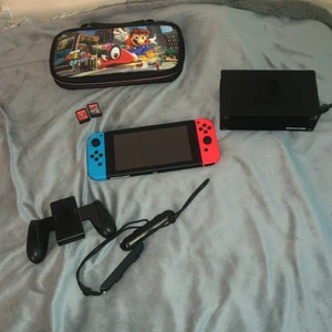 Nintendo switch inkl. 2 spel + väska - Hej! Jag säljer min Nintendo switch då den endast kom till användning i en kort period, den är i jättebra skick nästan som ny då den används endast några få gånger. Jag inkluderar själva konsolen, och alla tillbehören (som på bilden) inklusive tillbehörande sladdarna, men även en väska till den med bra utrymme för spelen. De två spelen är Mariokart (Deluxe) och Super Mario Odyssey. Pris kan diskuteras vid snabbaffär, varsågoda och buda!!!!🤍