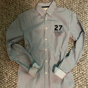 Skjorta Hampton Republic - En randig skjorta av 100% bomull och fin passform. Har använt den ett fåtal gånger, i jättefint skick. Passar S. Säljer den för att det inte passar mig vid bröstet.