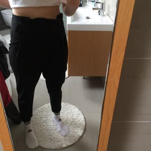 Svarta högmidjade byxor med spänne - Svarta högmidjade byxor med spänne. Säljs för att de inte används. Sitter ine riktigt bra på mig med bredare höfter. Köpta på HM för nåt år sedan, men inte använda mer än 2-3 gånger sedan dess. Materiallappen är bortklippt, så kan inte riktigt avgöra material. 