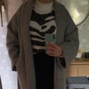 Lindex kappa i tjockt material - Grå Vinter/höstjacka från Lindex. Nypris 900kr men säljs för endast 250kr. Tjockt material, fodrad inuti. 2 vanliga fickor. Knappar samt 1 band runt midjan 