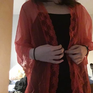 Kofta i nylon/silke med spets  - En väldigt lätt och luftig röd ”kofta” med spetsdetaljer! Går ner till höfterna ungefär. Typ aldrig använd. Köpt på en vintagebutik.  