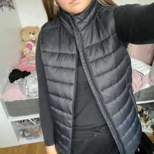 Svart Väst - Väst ifrån Everest, märket syns knappt. Köpt på barnavdelningen i storlek 170/176 & jag som har S/M passar den. Använd 2 gånger.