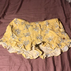 Gula shorts från kapphal - Jag säljer de här fina gul-blommiga shorts från kapphal. Satt lite konstigt på mig men ändå fina och sköna, jag har bara använt dessa några gånger och de är i väldigt fint skick. St 158-164. 