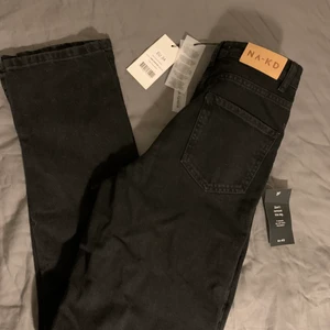 NAKD JEANS SVARTA S.34 - Svarta ekologiska jeans med slits på sidan. Helt oanvända, orginal pris 399. Säljer för att det var för stora för mig och glömde bort retur tiden ❤️