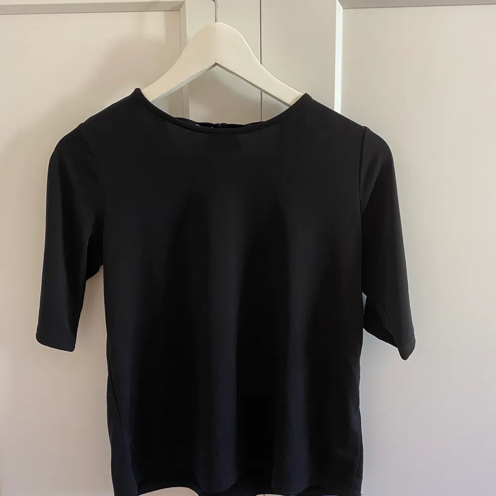 Säljer denna fina t-shirt blusen med öppen rygg från Gina Tricot. Säljer för att den aldrig har kommit till användning så den är i nytt skick🖤storlek XS men är stor i storleken. (köparen står för frakten). T-shirts.