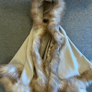 Snygg beige päls poncho  - Riktigt snygg päls poncho. Passar i storlek 36-40. Smickrande och skön. Skriv om ni vill se hur den ser ut på. 