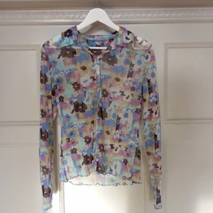 mönstrad mesh-skjorta i pastellfärger - en URFIN blommigt mönstrad skjorta i mesh som jag älskar men tyvärr aldrig använder. skjortan är i perfekt skick. färgen är i pastelltoner, men inte blekta alls. passar xs och s. materialet är töjbart och skjortan har lettuce hems.                                                                  jag möts upp i Malmö, annars betalar köparen en mindre summa för frakt. DMa för frågor/detaljer osv. 💌