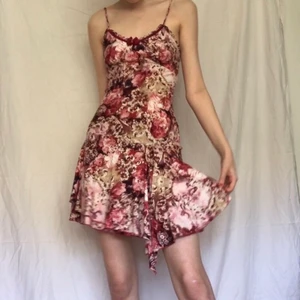 Y2k klänning slipdress - Skitcool och snygg klänning i y2k stil, typ rosaröd och vit mönstrad med låg midja och volangdetaljer längst ner. Ger juicy couture/ Paris Hilton vibes, snygg att ha till vardags eller fest. Verkligen unik med så fina detaljer. Jag är 179cm stl S men tyget är stretchigt så borde passa olika storlekar. Budgivning då flera var intresserade.