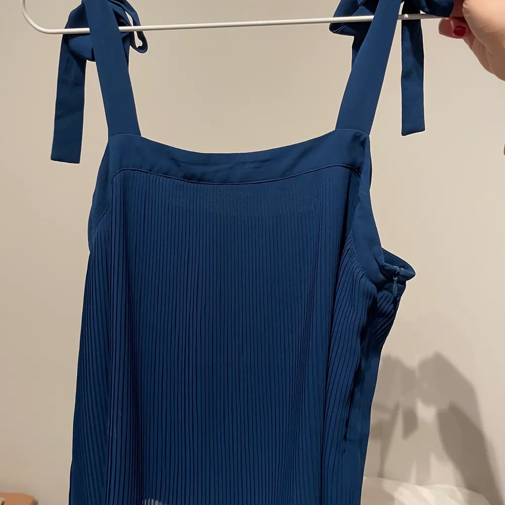 Plisserat blått linne från Samsøe. Aldrig använd men lappen är ej kvar! Säljer pågrund av att det inte kommer till användning:) Storlek M men justerbara band så passar flera storlekar!. Yläosat.
