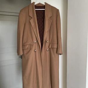 Beige kappa - Klassisk beige kappa köpt vintage i Stockholm! Den är superlång på mig som är 161 cm, så passar korta som långa beroende på hur man vill att den ska sitta! Kommer dessvärre inte till användning längre men den är verkligen så fin🤎