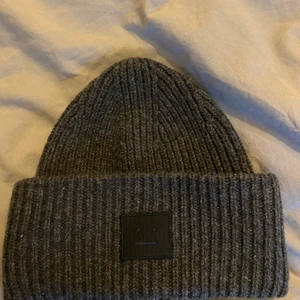 Acne mössa - Säljer min fina acne mössa som jag tyvärr inte har användning för längre. Knappt använd under en vinter. Orginalpriset jag köpte för är 1100kr (1200kr nu på marknaden) men säljer för 800kr.                                   Orginal förpackning + påse medföljer! 💕