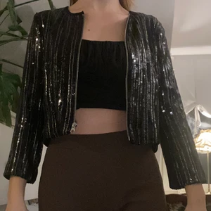 Svart kroppad paljettjacka. Stl small - Fin och hel croppad paljettjacka från zara. Perfekt inför nyår!  Aldrig använd (Lite kort i ärmarna för mig som är 1,74 lång)