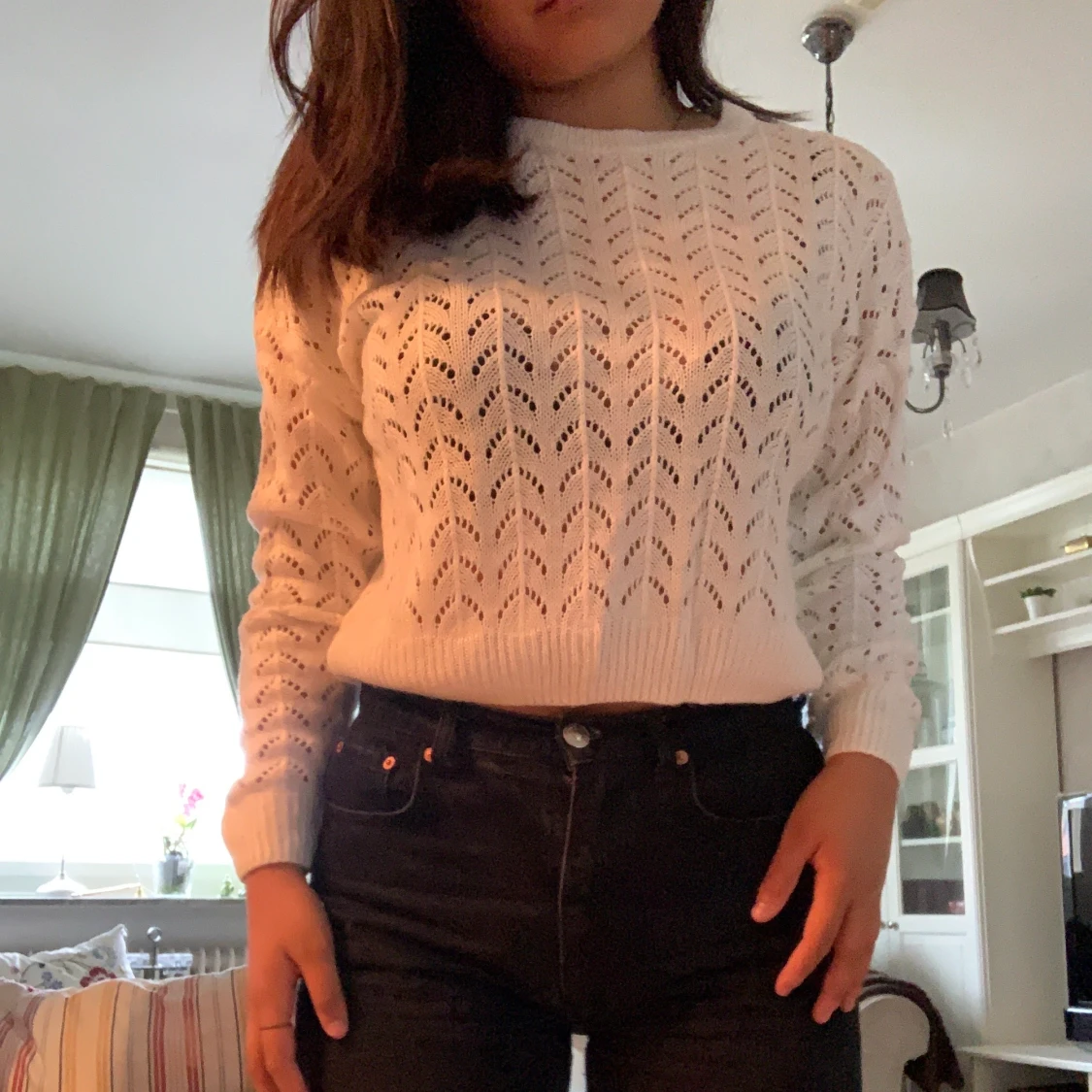 En stickad långärmad tröja med hål i sig