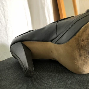 Klacksko - Svart hög klacksko i läderimitation, använd fåtal ggr, se bilder. Snygg sko med snygga detaljer, även på klacken. 