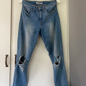 Levis jeans  - Väl använda Levis Jeans som är raka i passformen och har snygga hål på knäna! Köparen står för frakten!
