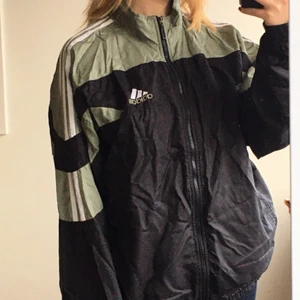 baggy adidaswindbreaker - svart och grön oversized windbreaker med dragkedja. Köpt secondhand 