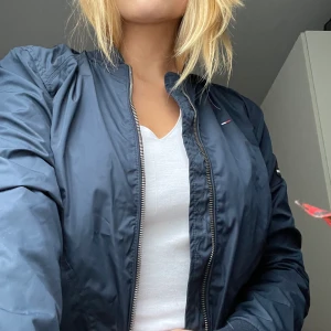 Hilfiger jacka - Jackan är en vår/sommar jacka som är vindtät och regnskyddad. Jackan köptes för över 1200. jacka som säljs pga att den inte använts. Kan mötas i Stockholm eller frakta. 