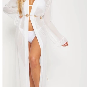 Strand kimono i storlek 12 - Jätte fin kimono som används på strand. Storlek uk 12 ( m ). Använd en gång på semester. Vid egen tagen bild vänligen kontakta mig :))))